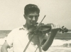 Joseph playing violin on the beach